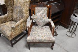 A Victorian mahogany armchair having spindle arm supports, later foliate upholstery and turned