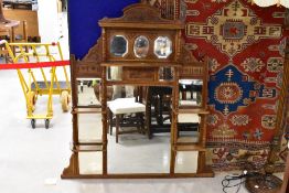 An Edwardian mahogany over-mantel mirror having an arched and stipple carved crest rail over three