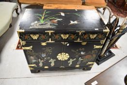 An Oriental ebonised side cabinet in the Japanese style having two drawers over double cupboard ,