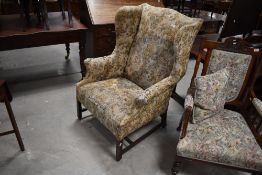 A 19th Century wingback armchair having later upholstery