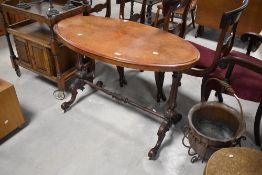 A Victorian inlaid occasional table having oval top with turned frame and scroll feet on castors,