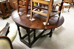 A Victorian oak gate legged dining table, of traditional design with demi-line flaps and block and