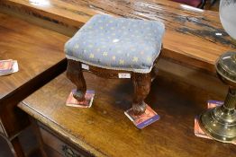 A modern footstool having shaped carved legs, approx. 29 x 29cm