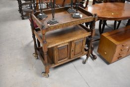An early to mid 20th Century oak tea trolley having cupboard base under, approx. 70 x 45cm