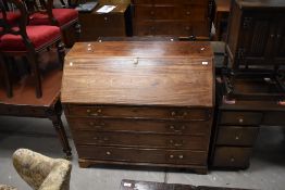 A Georgian mahogany bureau having fitted interior beneath fall flap , over four long drawers and