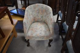 An early to mid 20th Century tub armchair having floral upholstery and cabriole legs
