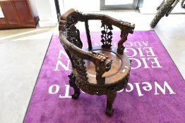 An Oriental hardwood chair in the Chinese style, having heavily carved decoration including dragon