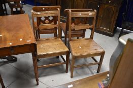 A pair of Georgian oak farmhouse style chairs having solid seats and shaped rail back, seat width