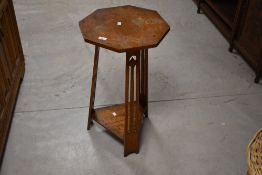 An Arts & Crafts golden oak occasional table , having octagonal top and triple supports with
