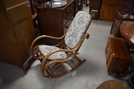 A vintage bentwood rocking chair having foliate upholstery