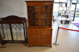 An early 20th Century oak bookcase having glazed section over double drawers and cupboard,