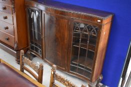 An early 20th century display cabinet having serpentine front with central enclosed cupboard flanked