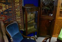 An Edwardian mahogany display cabinet of small proportions having bowed leaded glass doors, with