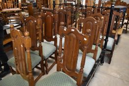 A set of ten (eight plus two) traditional oak dining chairs having panel backs, overstuffed seats