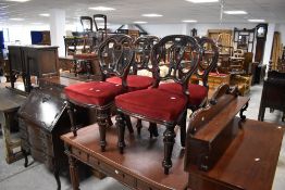 A set of four Victorian mahogany balloon back dining chairs having red velvet upholstered seats,