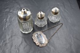 A pair of George V silver topped glass salt and pepper, of octangonal form having silver screw tops,
