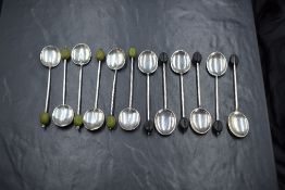 Two sets of six George V silver coffee bean spoons, one set having black 'beans' to terminals, the