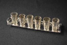 A set of six Mexican silver mounted shot glasses, the silver mounts of pierced floral design on a