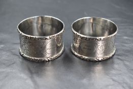 A cased pair of 20th century silver napkin rings, having scroll decoration with 'The Manager' and '