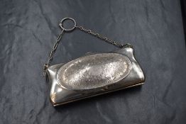 A George V silver purse, of rectangular form having central oval panels of scroll decoration with