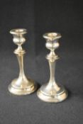 A pair of 20th century silver candle sticks, the circular sconces having moulded rims, raised on