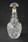 A 20th century silver mounted glass decanter, the flared silver top over a step moulded neck and
