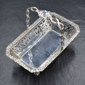 A George V silver basket, of rectangular form having a woven handle, floral rim and pierced