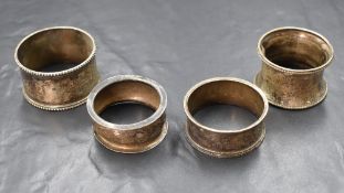 A group of four silver napkin rings, comprising two Victorian examples having floral engraving and