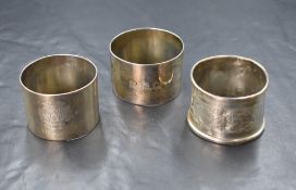 A group of three silver napkin rings, one with 'EMC' monogram and '5th Aug 1921', one with 'R.M.C'