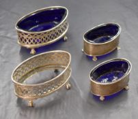 A pair of George V silver salts, of oval form having moulded rims, raised on four claw feet, with