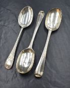 A pair of white metal presumed silver Hanoverian rat-tail pattern serving spoons, having rubbed