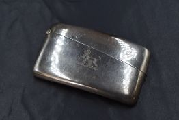 A Victorian silver card holder, of hinged rectangular form, curved for the pocket with a heraldic