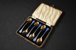 A cased set of six George V silver and enamel teaspoons, having blue guilloche enamels to the