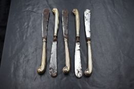 A group of five Victorian silver handled butter knives, having scroll motif handles, marks for
