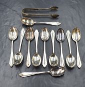 A cased group of eleven George V silver teaspoons, with matching sugar tongs, having decorative