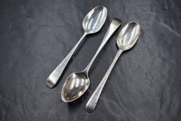 A group of three silver Old English pattern teaspoons, two having monograms to terminals, marks