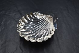 An Edwardian silver dish, of scalloped form raised on three ball feet, marks Sheffield 1901, maker