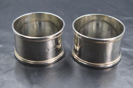 A cased pair of Edwardian silver napkin rings, having bead thread, rubbed marks for Birmingham 1907,
