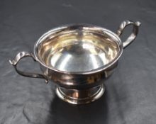 A George V silver sugar bowl, of traditional form having a flared rim with two scroll handles,