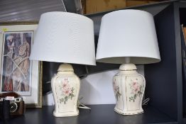 Two 20th-century ceramic table lamps, having delicate pink floral decoration with gilded detailing