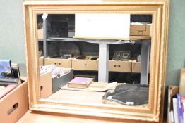 A modern wall mirror having a gilt moulded frame measuring 62cm x 52cm x 4.5cm.
