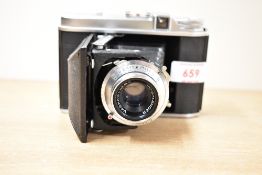 A Voigtlander folding camera in leather cover