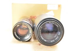 Two camera lenses. A boxed Sigma 100-300mm 1:4,5-6,7 and a Zenet Jupiter A-11 135mm 1;4 lens with
