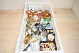 An assortment of costume jewellery, including faux amber beads, brooches and clip-on earrings