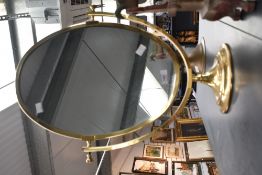 A fine large 20th-century brass oval vanity table mirror, upon a graduated circular base,