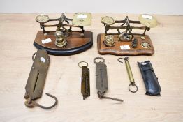 Two early to mid 20th-century brass postal balance scales, upon a wooden base having a small