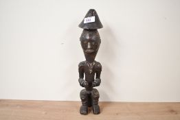 A late 19th to 20th century African Tribal Art hand carved male figural sculpture, featuring a