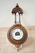 A Victorian walnut-cased banjo-style barometer with integrated thermometer, having a porcelain
