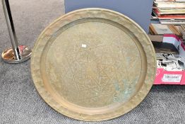 A large 20th-century brass Middle Eastern charger, having central geometric floral detailing and