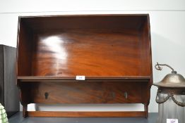A presumed early 20th-century mahogany wall shelf, having a polished main shelf and small sections
